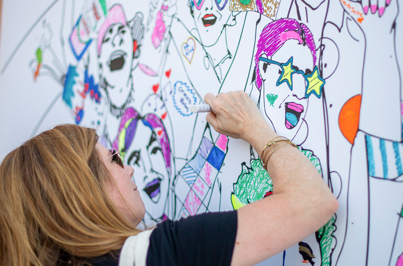 Woman drawing part of a mural