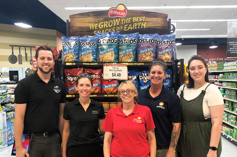 Frito-Lay employees standing in front of an in-store display of chips