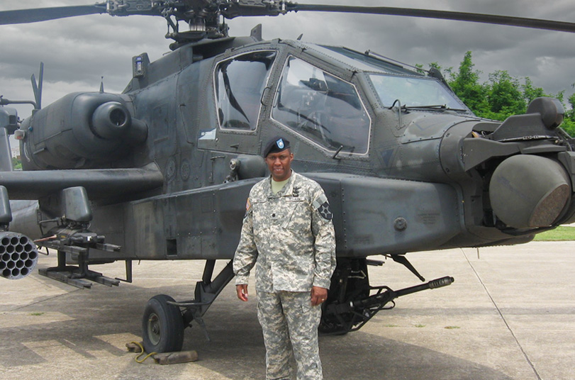 photo of Kevin Berry in front of an Apache helicopter