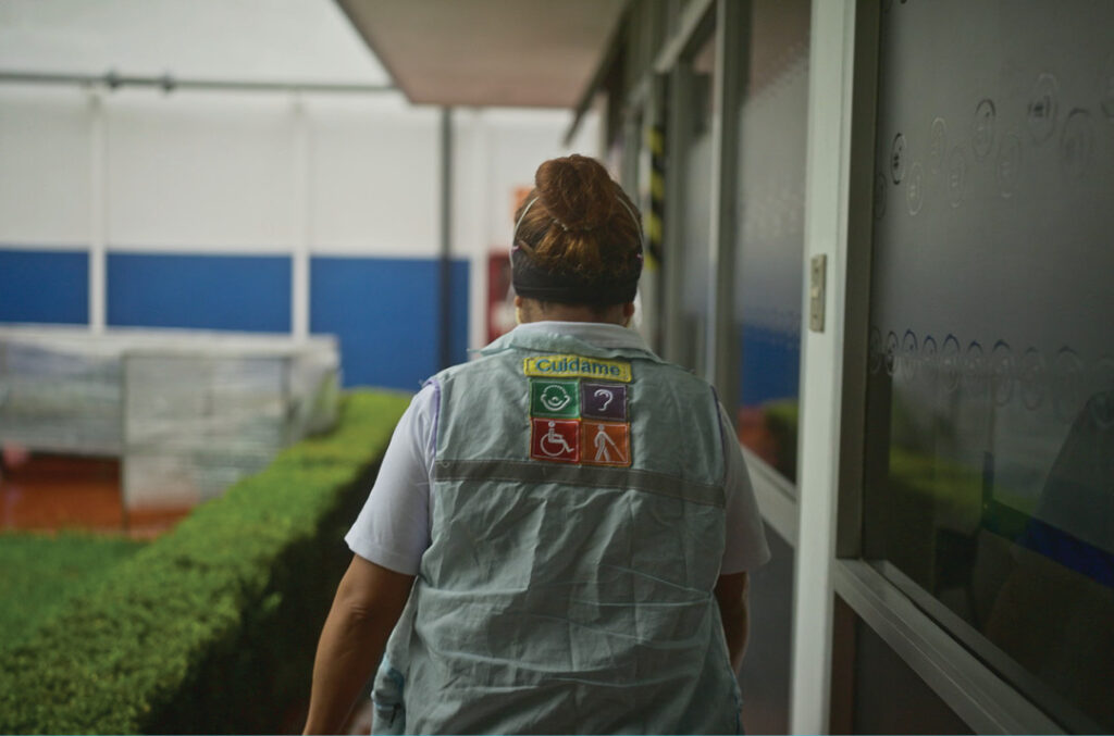 Adriana walks into her workplace wearing a vest and protective face coverings. | International Day of Persons with Disabilities