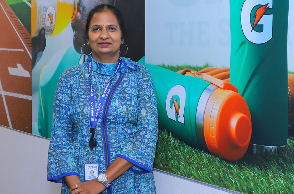 STEM associate Sridevi Chatta smiles in front of Gatorade advertisement